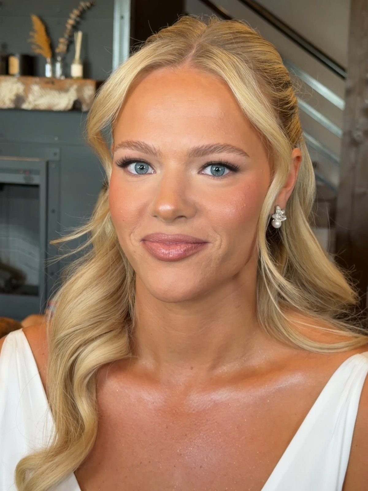 Blonde woman with natural bridal makeup and groomed feathered eyebrows wearing white dress