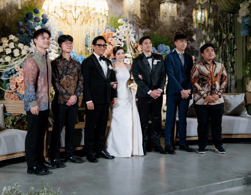 Wedding party posing together with a bride in white and men in formal attire.