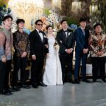 Wedding party posing together with a bride in white and men in formal attire.
