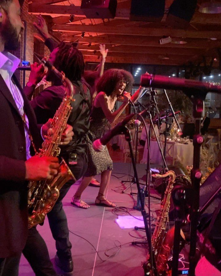 Live band with saxophone and singer performing at a wedding reception event.